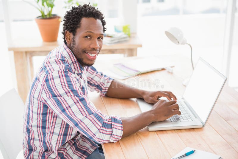 Smiling young businessman in front of the laptop, Smiling young businessman in front of the laptop looking at the camera in the office model released