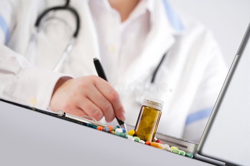 Doctor writing a prescription, Doctor writing a prescription. Pills on the desk