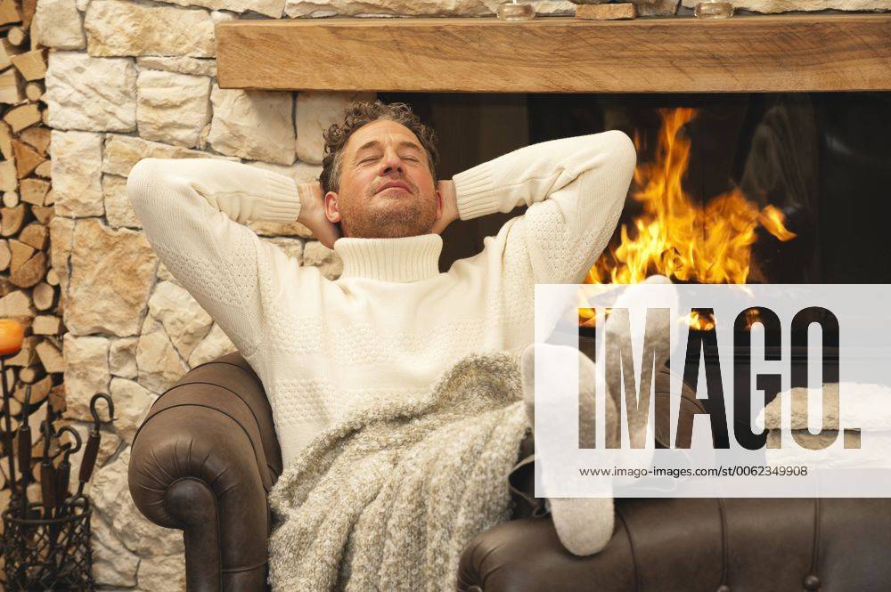 Man sitting in front of fire place, eyes closed, portrait model released property released WEST11578