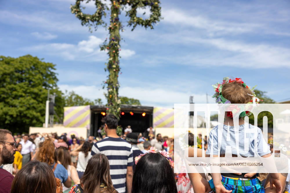 Mittsommer in Schweden Malmoe, Schweden - 21.6.2024: Menschen schmücken ihre Haare mit Blumenkränzen und feiern und tanzen um einen Midsommarstang Mittsommer im Folkets Park in Malmoe in Schweden.