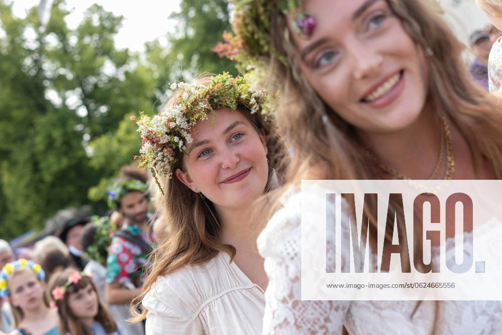 Mittsommer in Schweden Malmoe, Schweden - 21.6.2024: Menschen schmücken ihre Haare mit Blumenkränzen und feiern und tanzen um einen Midsommarstang Mittsommer im Folkets Park in Malmoe in Schweden.