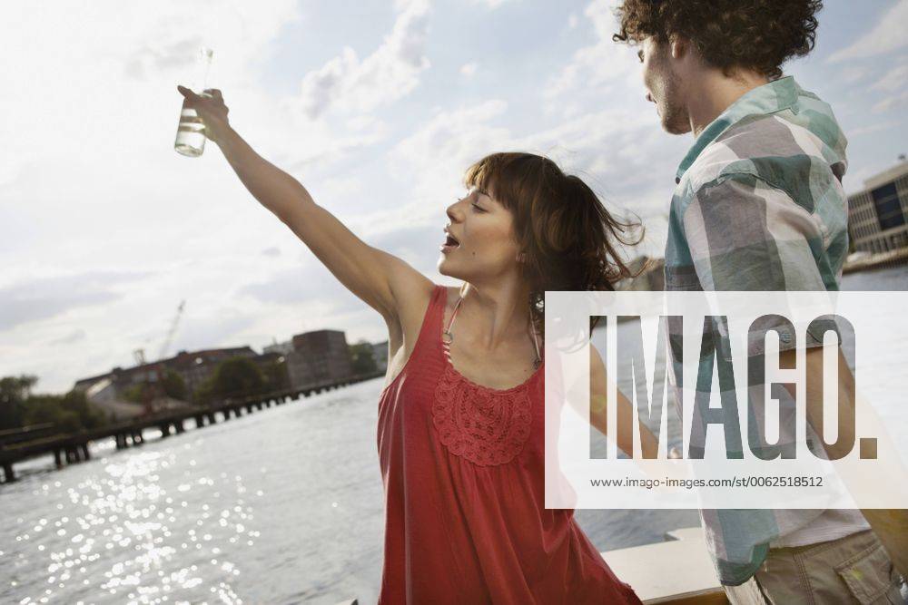 Germany, Berlin, Young couple on motor boat, woman dancing model released VVF00061
