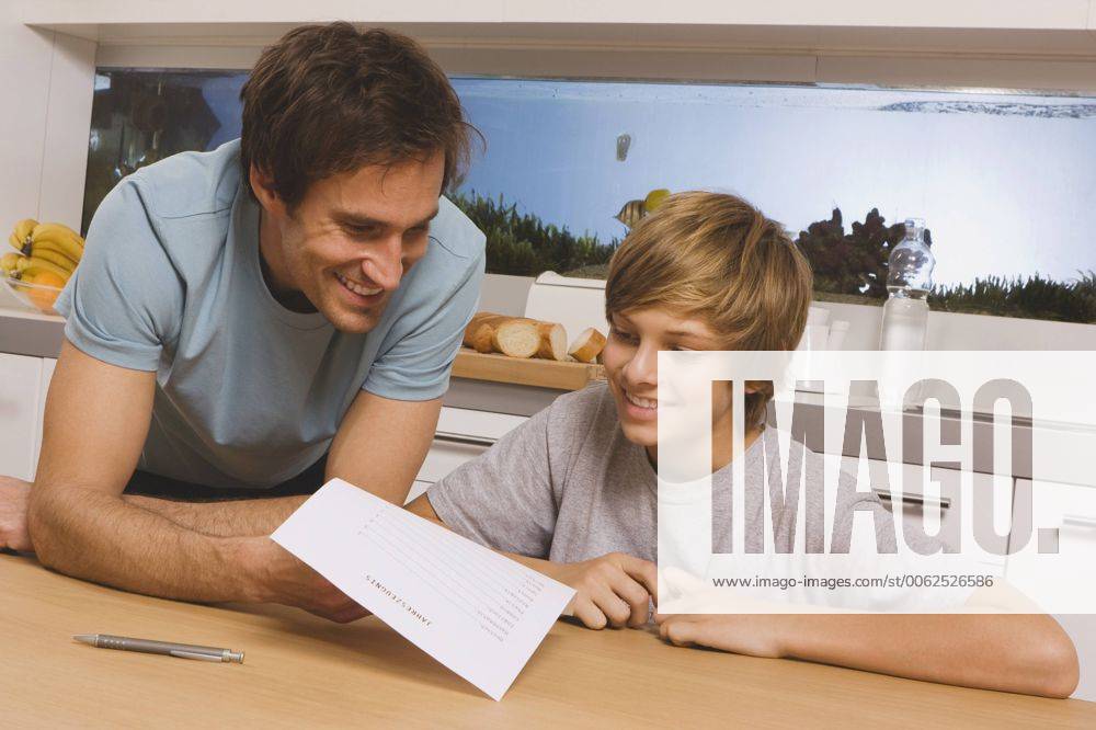 Father and son (13-14) looking at report card model released WESTF11056