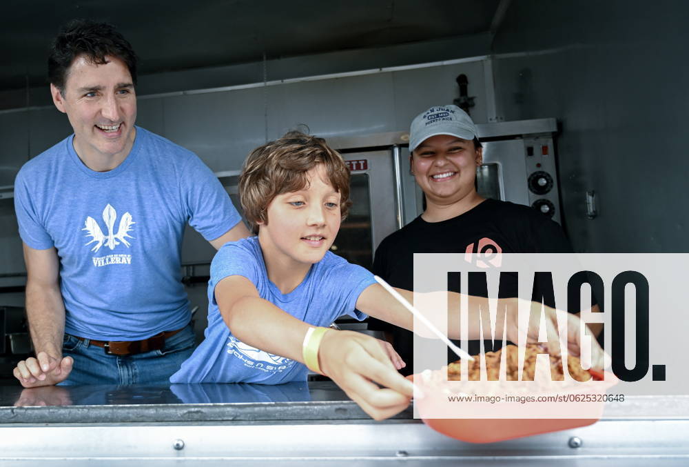 Prime Minister Justin Trudeau and son Hadrien serve a poutine as they visit a poutine festival in Chateauguay, Que., Sunday, June 23, 2024. Chateauguay Canada - ZUMAc35_ 20240623_zaf_c35_001