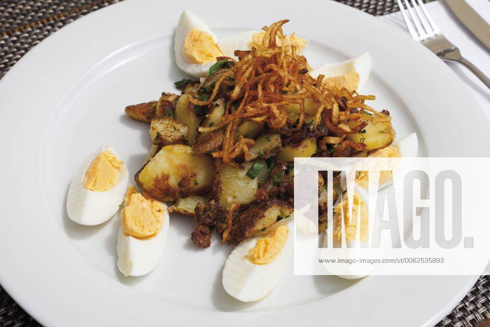 Close up of hard boiled eggs with roasted potatoes and onions CSF015124