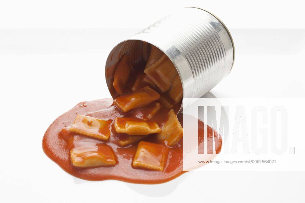 Filled ravioli pouring out of tin on white background CSF018025