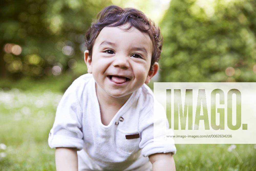 Baby boy crawling on grass, smiling model released MFF000555