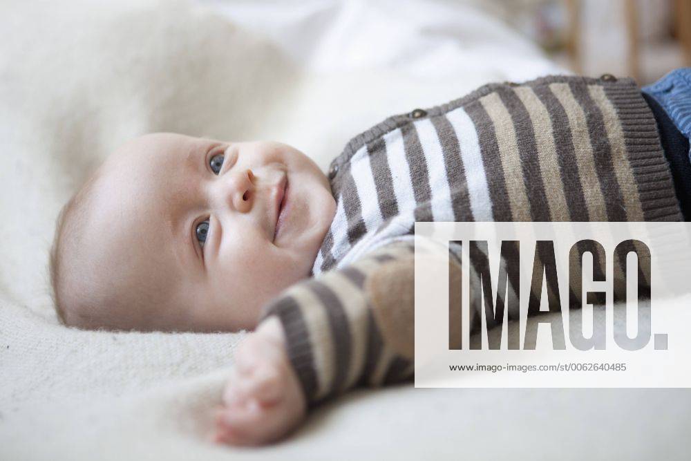 Portrait of happy baby boy lying on blanket model released property released RBF001604