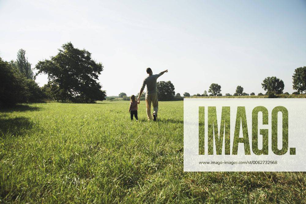 Father walking with his little daughter on a meadow model released Symbolfoto UUF001522