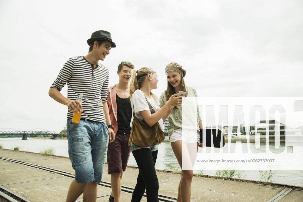 Group of friends walking at the riverside model released Symbolfoto UUF001389