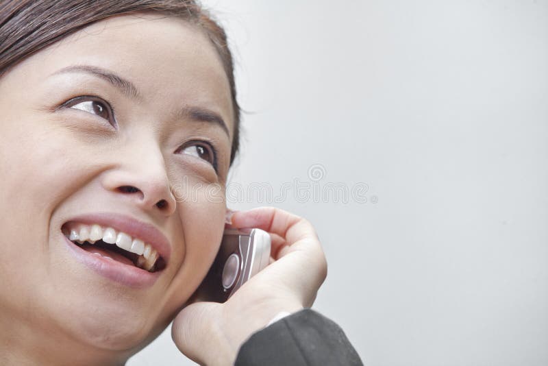 Close up of smiling businesswoman talking on the phone in Beijing, Close up of smiling businesswoman talking on the phone in Beijing model released