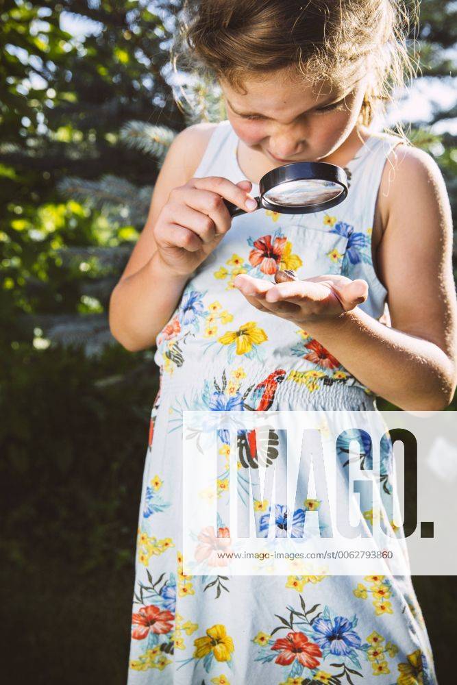 Germany, Northrhine Westphalia, Bornheim, Girl examining snail with magnifying glass model released Symbolfoto property released MFF001214