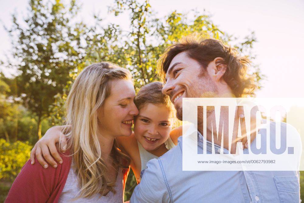 Happy family of three in garden at sunset model released Symbolfoto property released MFF001323