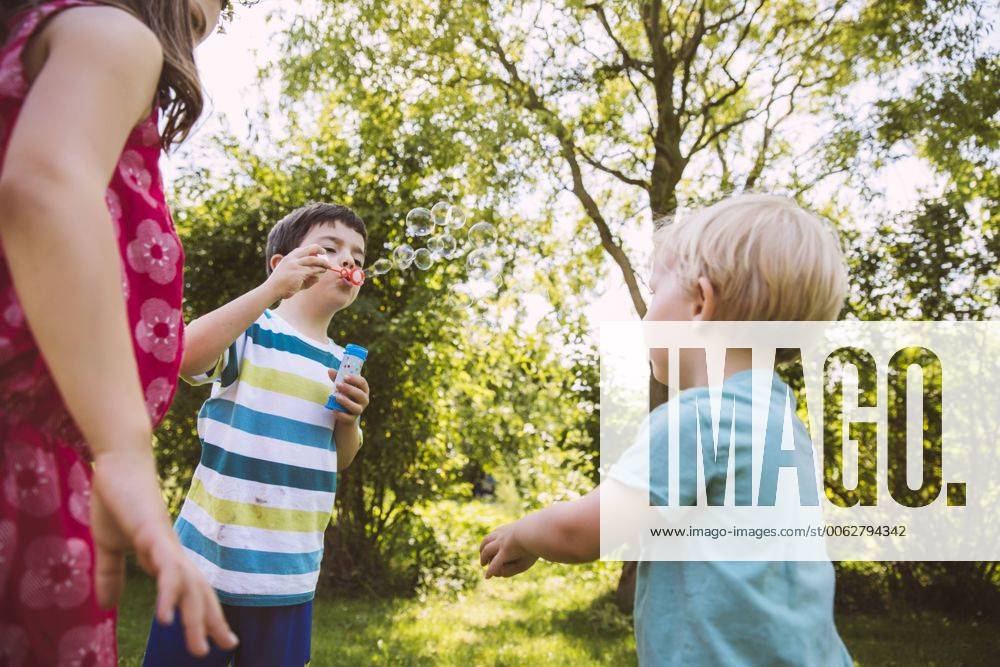 Children blowing soap bubbbles in garden model released Symbolfoto property released MFF001277