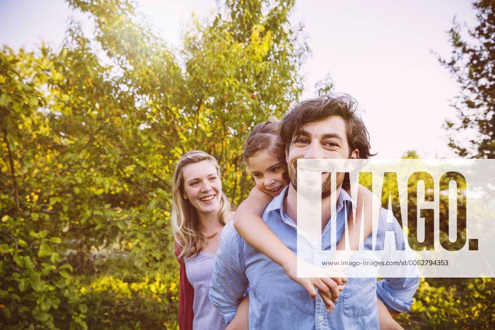 Happy family of three in garden at sunset model released Symbolfoto property released MFF001322