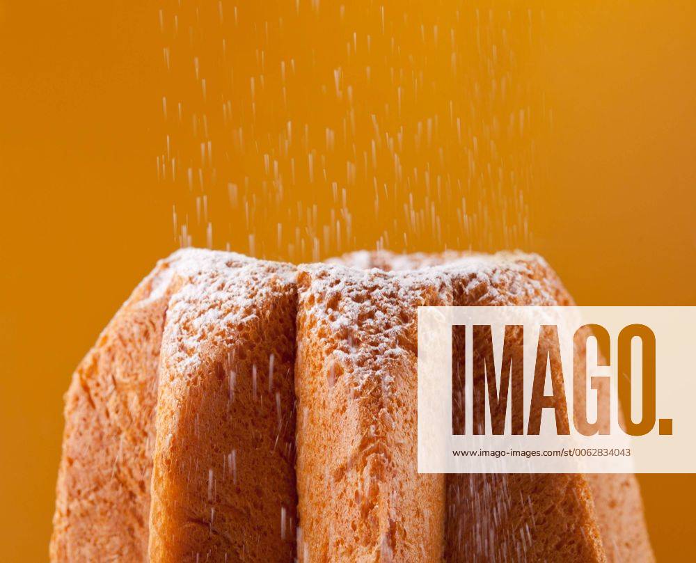 Pandoro with dusting of icing sugar on orange background 1085302079