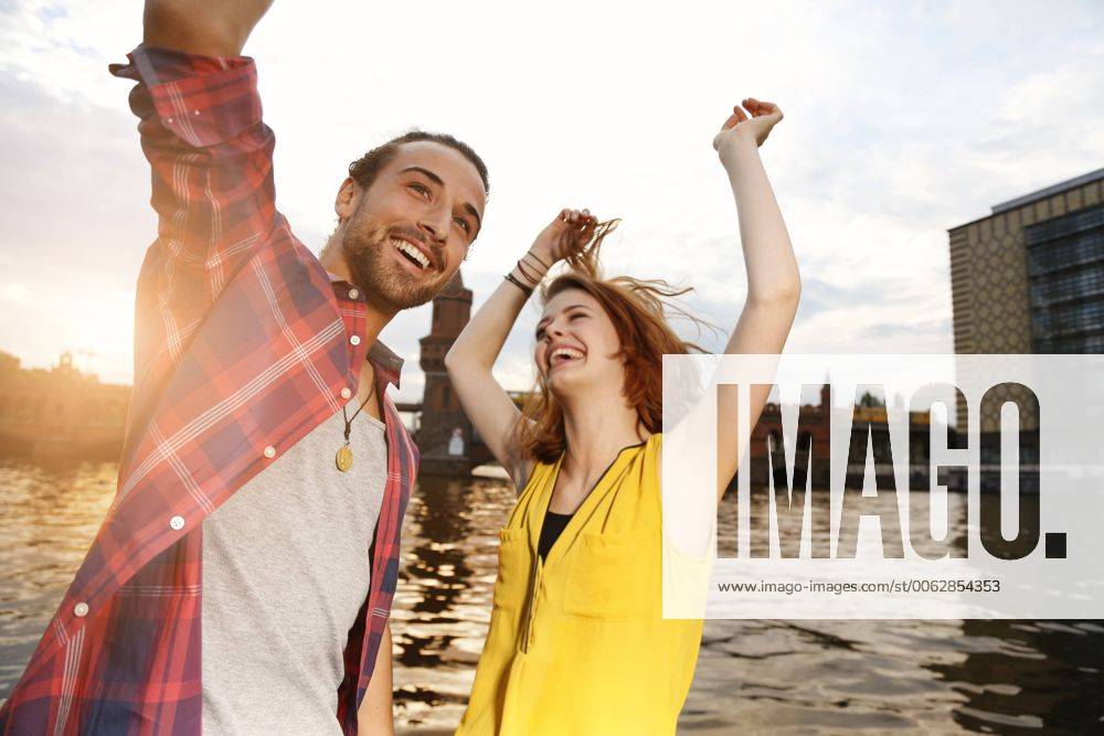 Germany, Berlin, Young couple enjoying sunset at Spree river model released Symbolfoto FKF000674