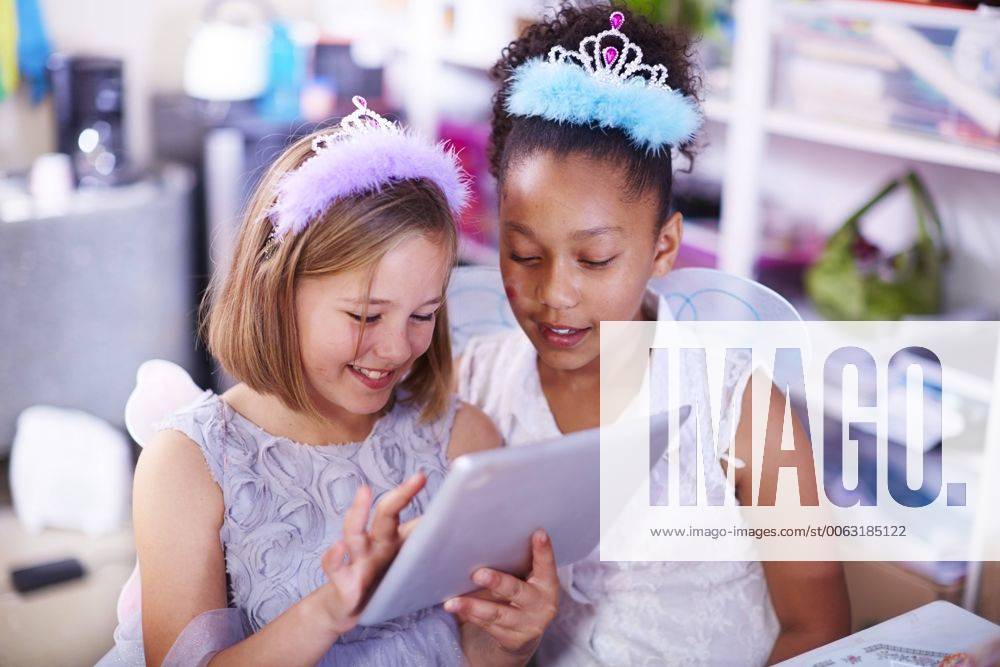 Two girls using digital tablet on a birthday party model released Symbolfoto property released ZEF001372