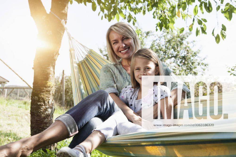 Happy mother and daughter sitting in hammock model released Symbolfoto RBF001963