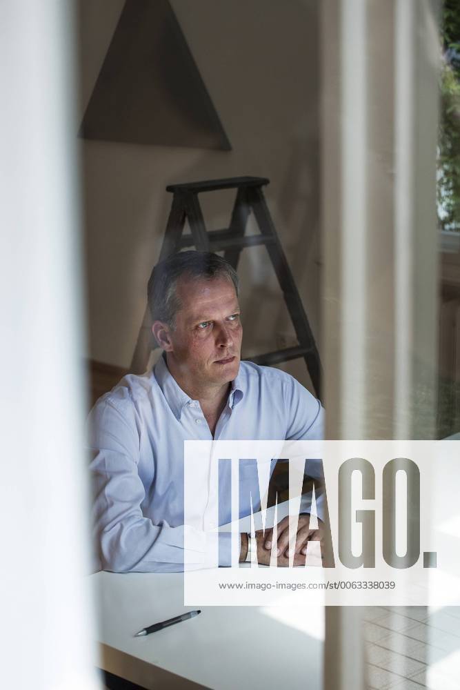 Galerist Daniel Marzona Rüsternallee 22 14050 Berlin (Kunstwerke im Hintergrund: Alan Charlton (dreieckiges Gemälde) und Jürgen Drescher (Leiter-Skulptur))