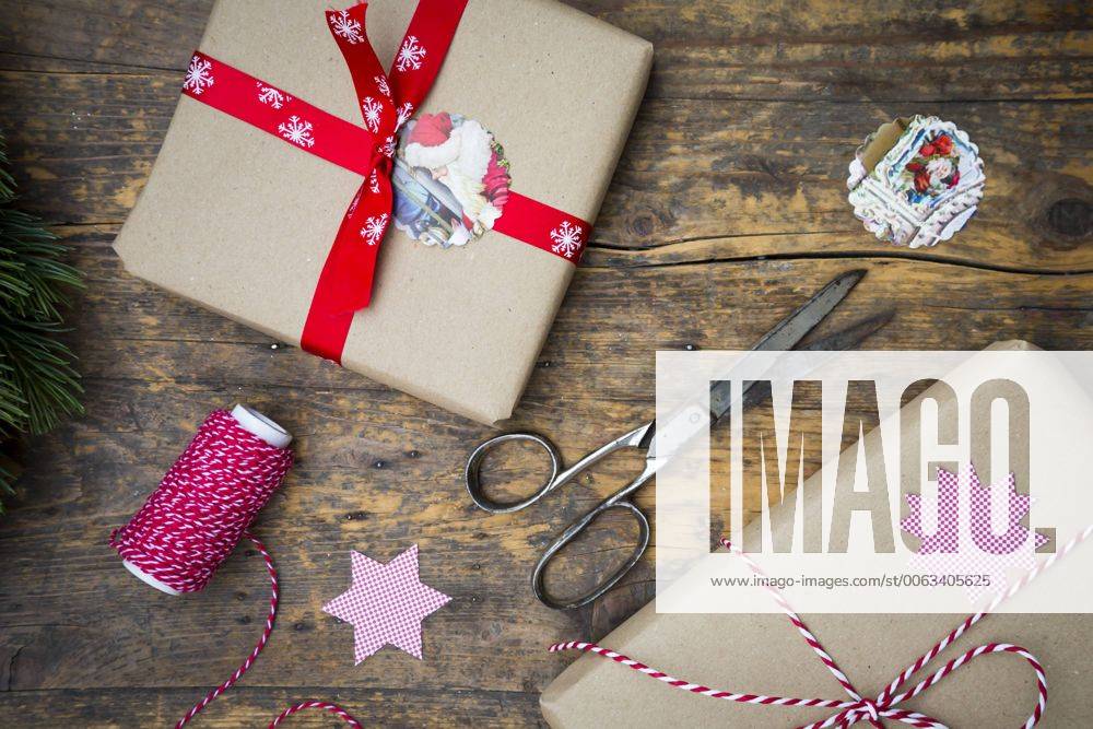 IMAGO Creative: Weihnachten, DIY, Geschenke verpacken - Nachhaltigkeit Wrapped Christmas presents and scissors on dark wood LVF002407