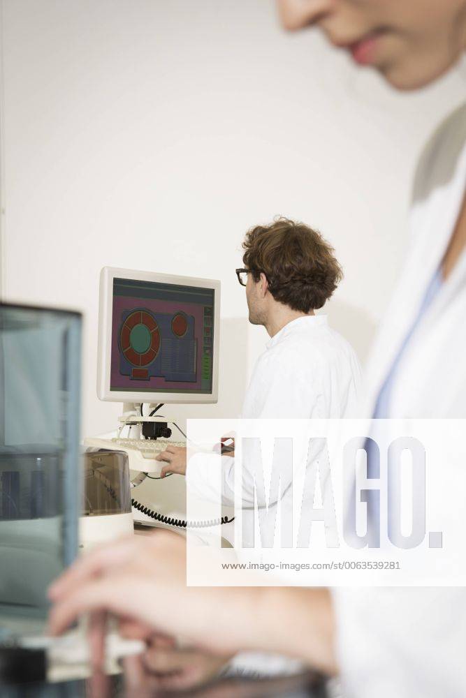 IMAGO Creative: Business, Innovative Technologie-Lösungen Scientists working in laboratory, Scientist looking to screen model released Symbolfoto property released FKF000887