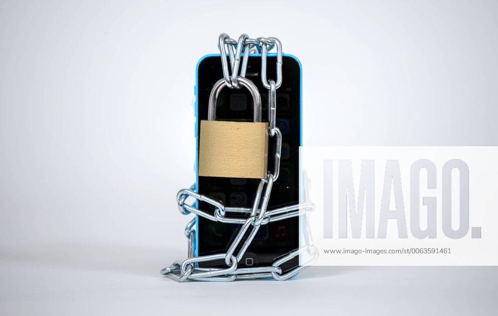 Ein Smartphone wird von einer Eisenkette samt Schloss umschlossen, aufgenommen am 27.01.2015.