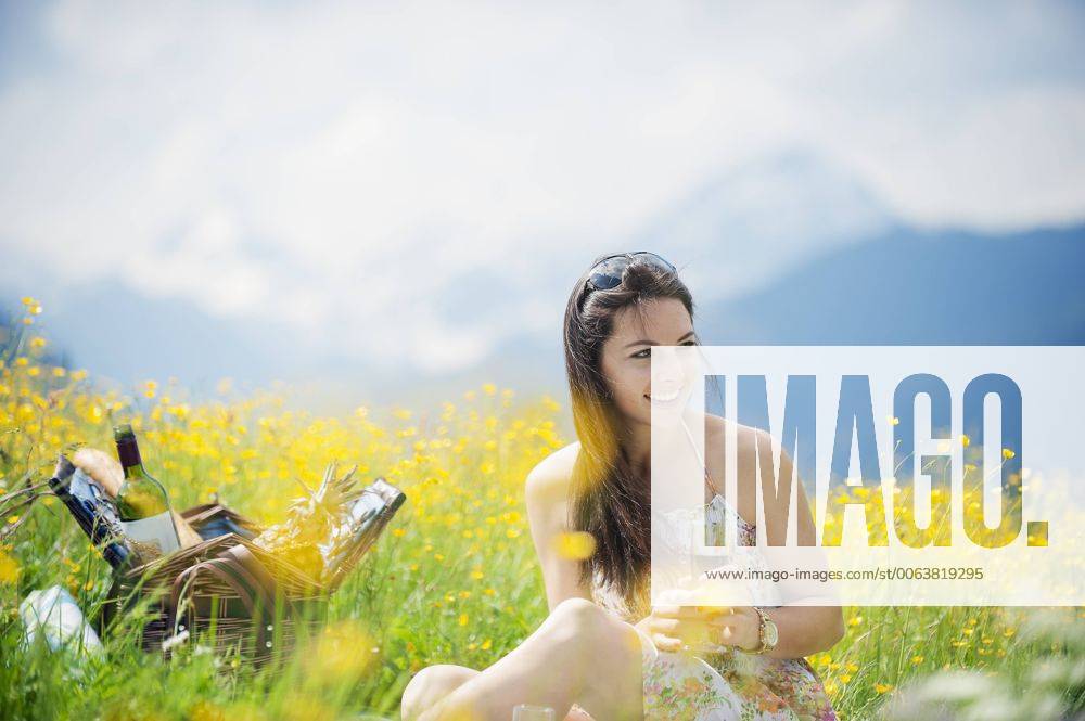 Young woman having picnic on alpine meadow model released Symbolfoto HHF005031