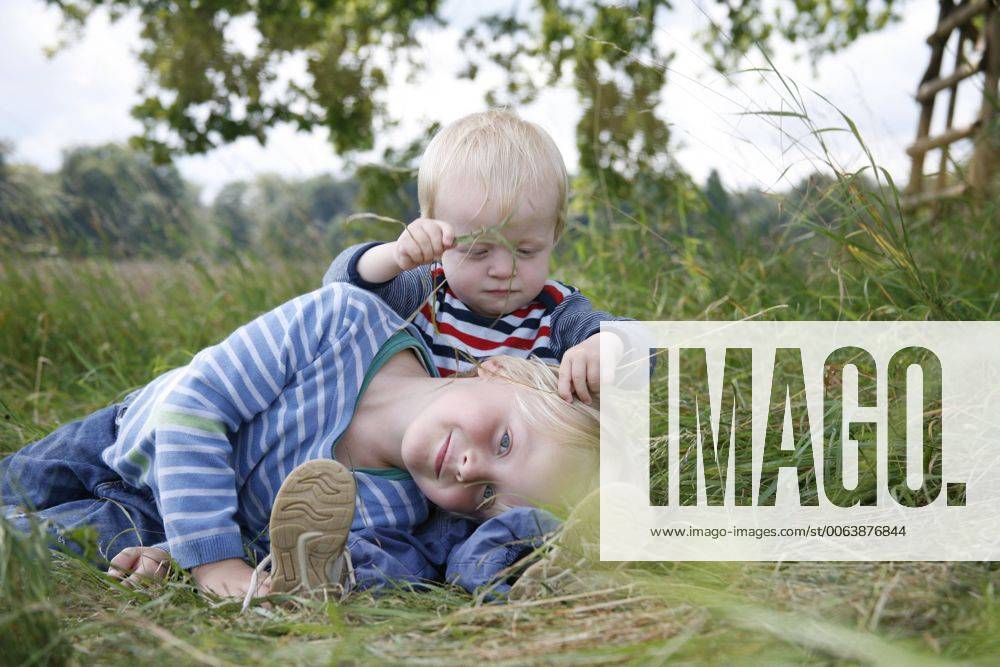 Two little brothers on a meadow model released Symbolfoto RB002253