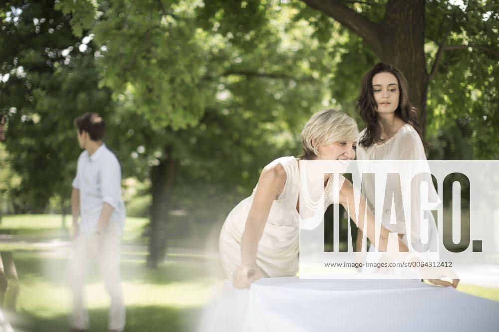 Woman setting a table outside model released Symbolfoto property released ZEF003437