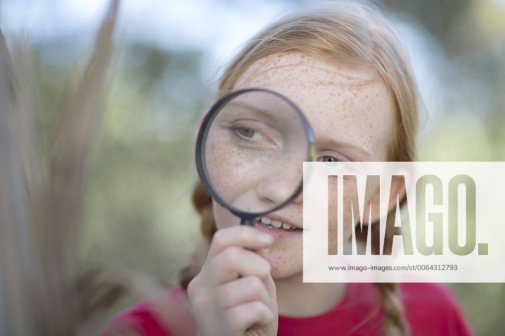 South Africa, Girl on field trip looking through magnifying glass model released Symbolfoto ZEF003929