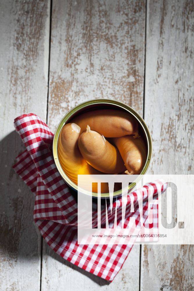Preserve can of sausages and cloth on wood CSF024982