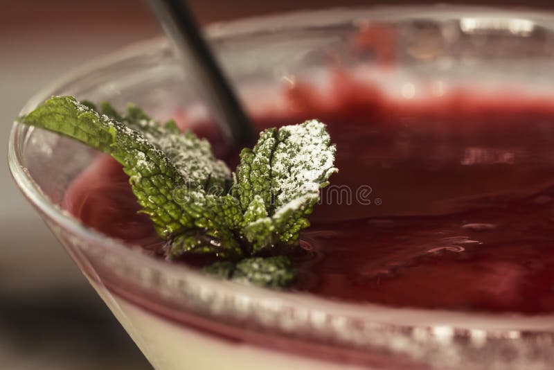 Photo of italian panna cotta dessert with strawberry sirup and mint leaf, soft focus, Photo of italian panna cotta dessert with strawberry sirup and mint leaf, soft focus.