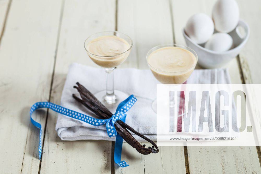 Two glasses of egg liqueur and vanilla beans on cloth SBDF002025
