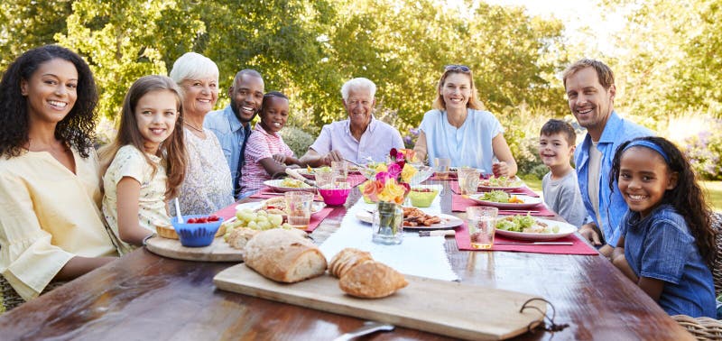 Friends and family having lunch in garden, looking to camera, Friends and family having lunch in garden, looking to camera