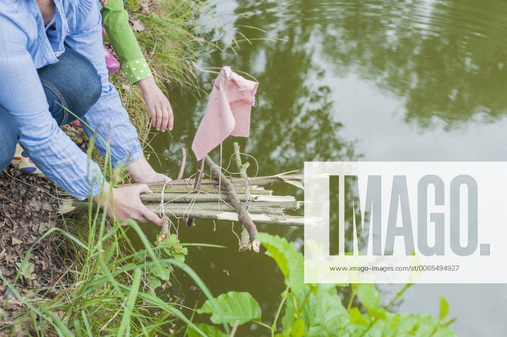 Germany, Woman putting toy raft in water model released Symbolfoto MJF001567