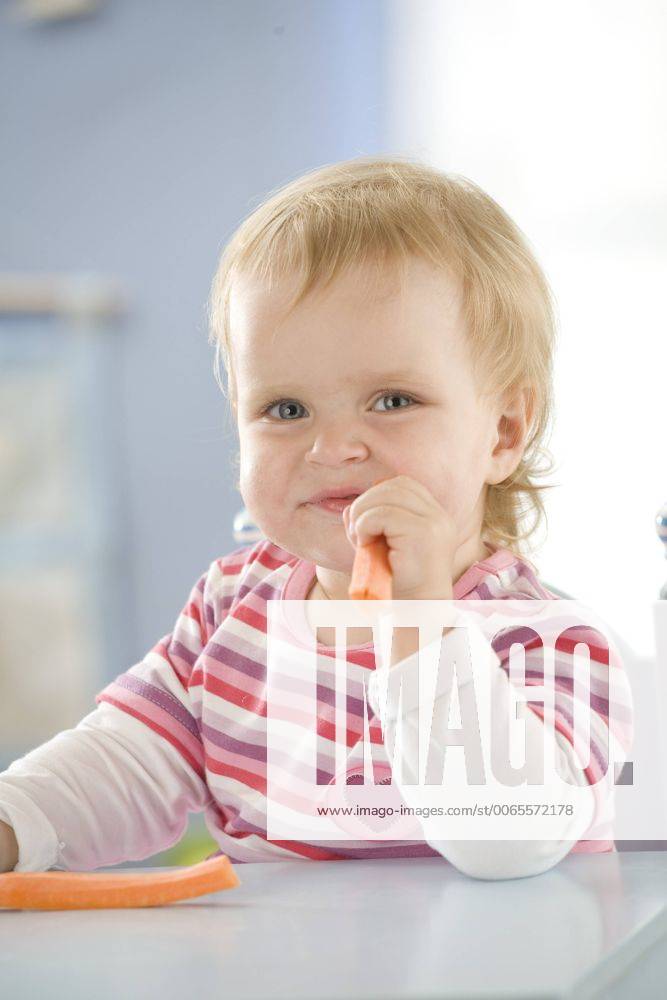 Little girl eating a carrot. Children00456