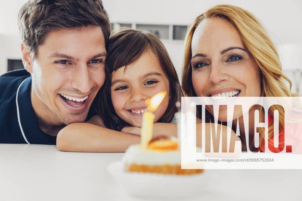 Geburtstag - Symbolbilder Family with daughter celebrating birthday with candles on cake model released Symbolfoto property released CHAF000993