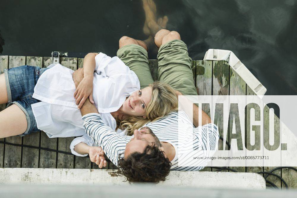 Smiling woman lying on man s lap at the water model released Symbolfoto property released FMKF001944
