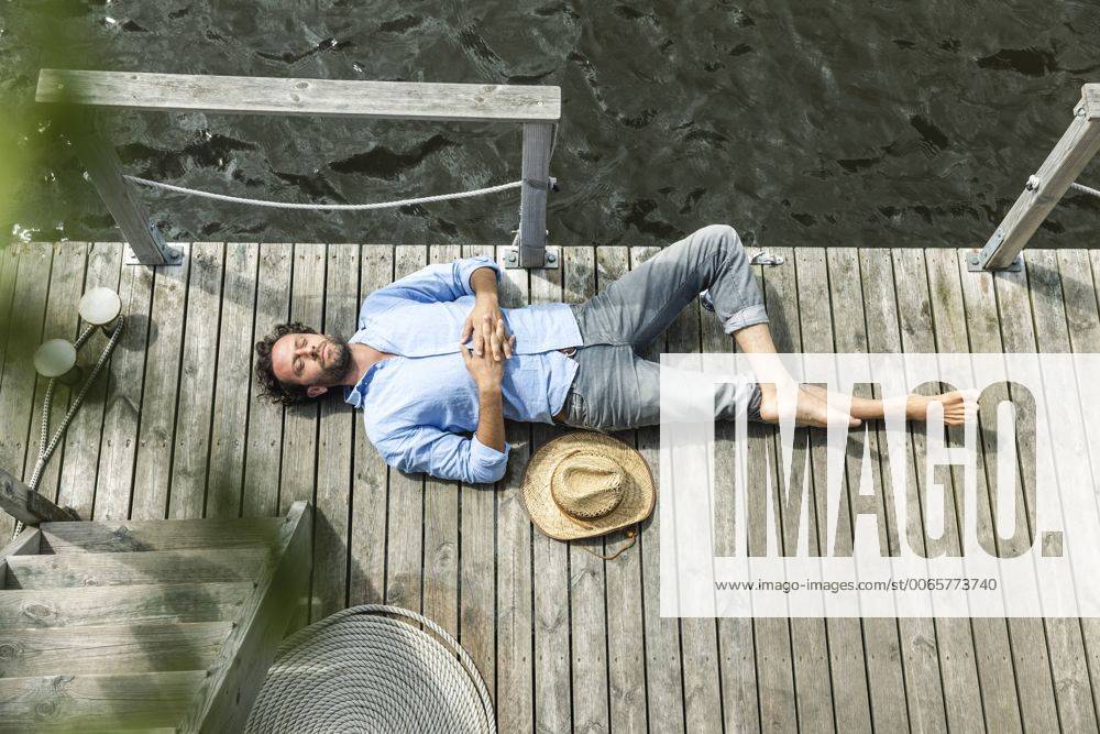 Man lying on platform at the waterside model released Symbolfoto property released FMKF001967