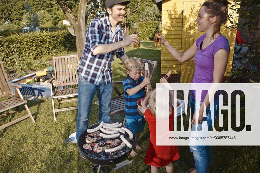 Family having a barbecue in garden model released Symbolfoto property released RHF001021