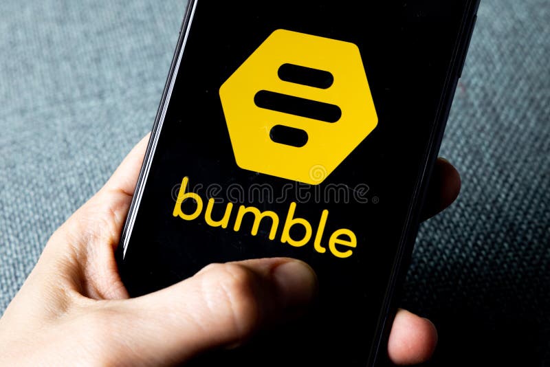 Hand holding a smartphone with a Bumble dating icon on screen., Hand holding a smartphone with a Bumble dating icon on screen. IPhone 11 with a social media app logo.
