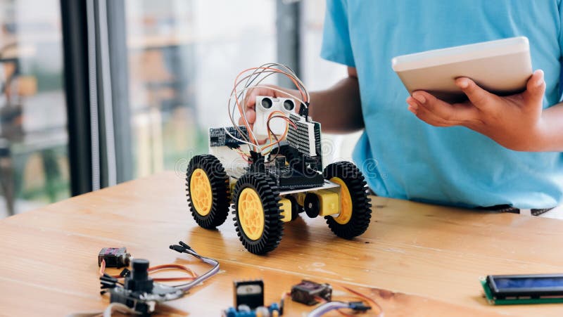 Boy with tablet pc computer programming electric toys and building robots, Boy with tablet pc computer programming electric toys and building robots. Education, science, technology, children and people concept
