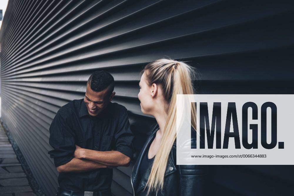 Black dressed young couple standing in front of black facade model released Symbolfoto CHAF001373