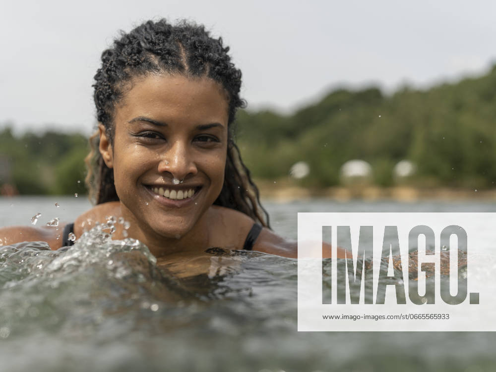 Portrait of smiling woman swimming in lake model released