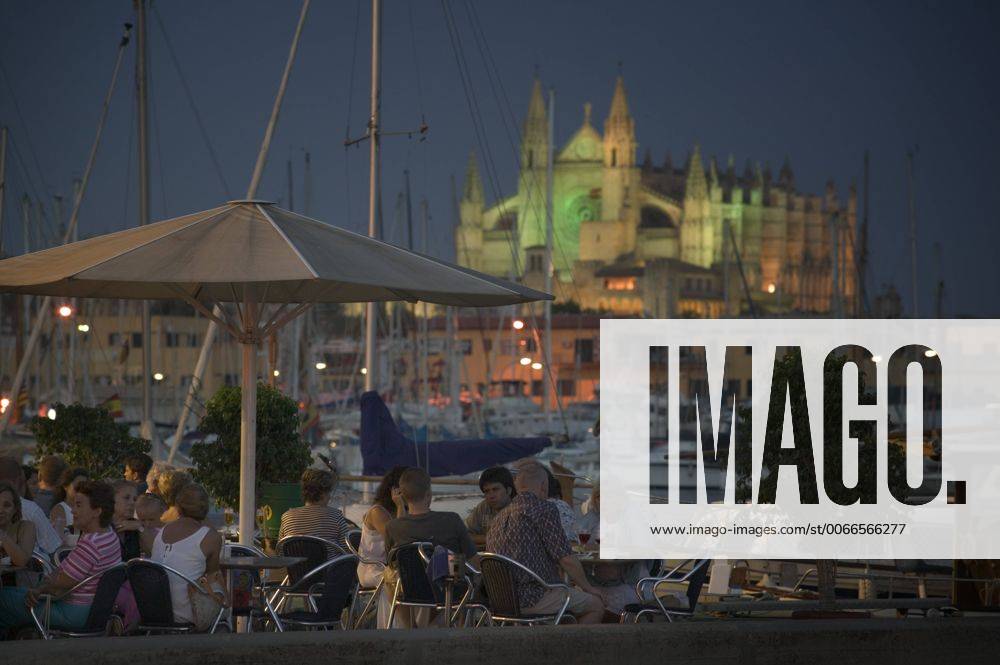 Spain, balearic islands, mallorca, palma de mallorca cafe with the cathedral behind set in the evening.