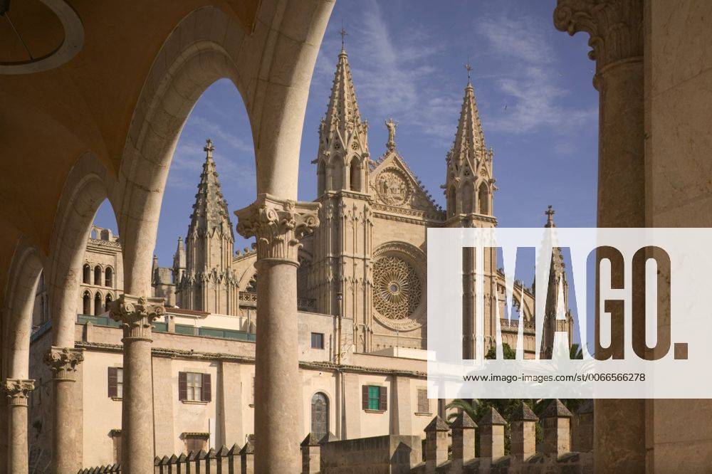 Spain, balearic islands, mallorca, palma de mallorca view of the cathedral from under a row of arches.