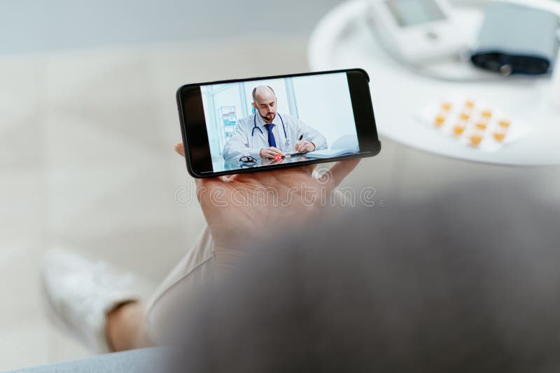 Woman using her smartphone to communicate with a home doctor., close-up. a woman using her smartphone to communicate with a home doctor. Telehealth concept. model released