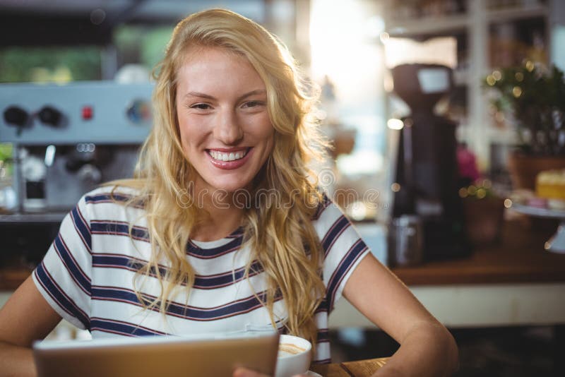 Woman sitting in a cafe using digital tablet, Portrait of woman sitting in a cafe using digital tablet model released