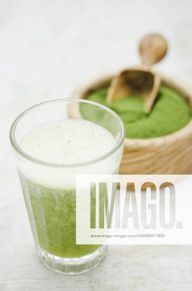 Moringa smoothie with orange and lemon juice, moringa powder in wooden bowl CZF000224